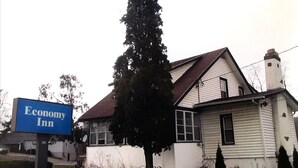 A two-story building with a sign for Economy Inn. - Economy Inn Ithaca (Ithaca)