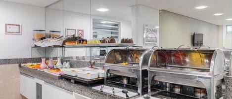 Una mesa de buffet con diferentes alimentos y utensilios para servir.