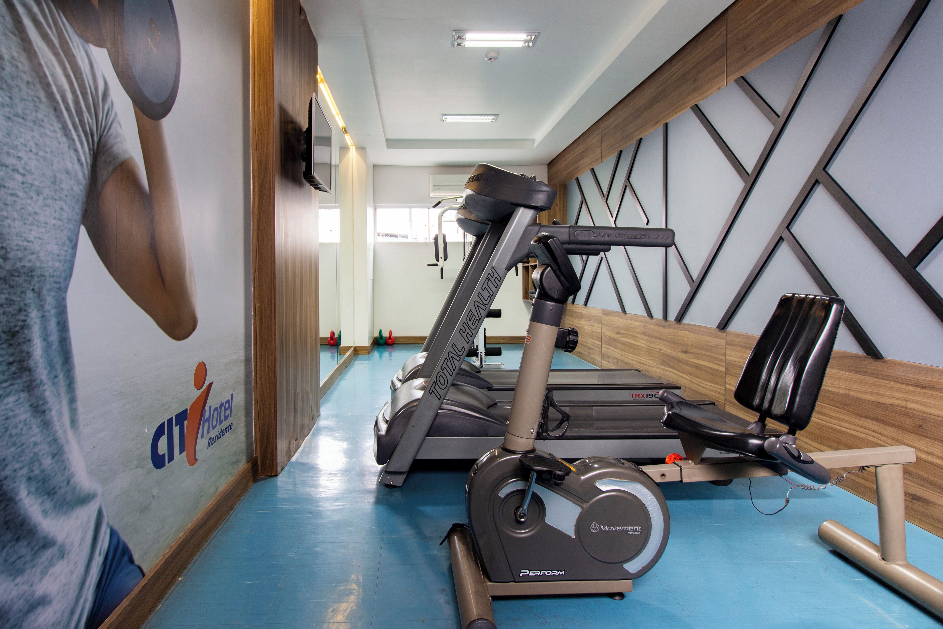 A gym with treadmills, stationary bikes, and exercise equipment.