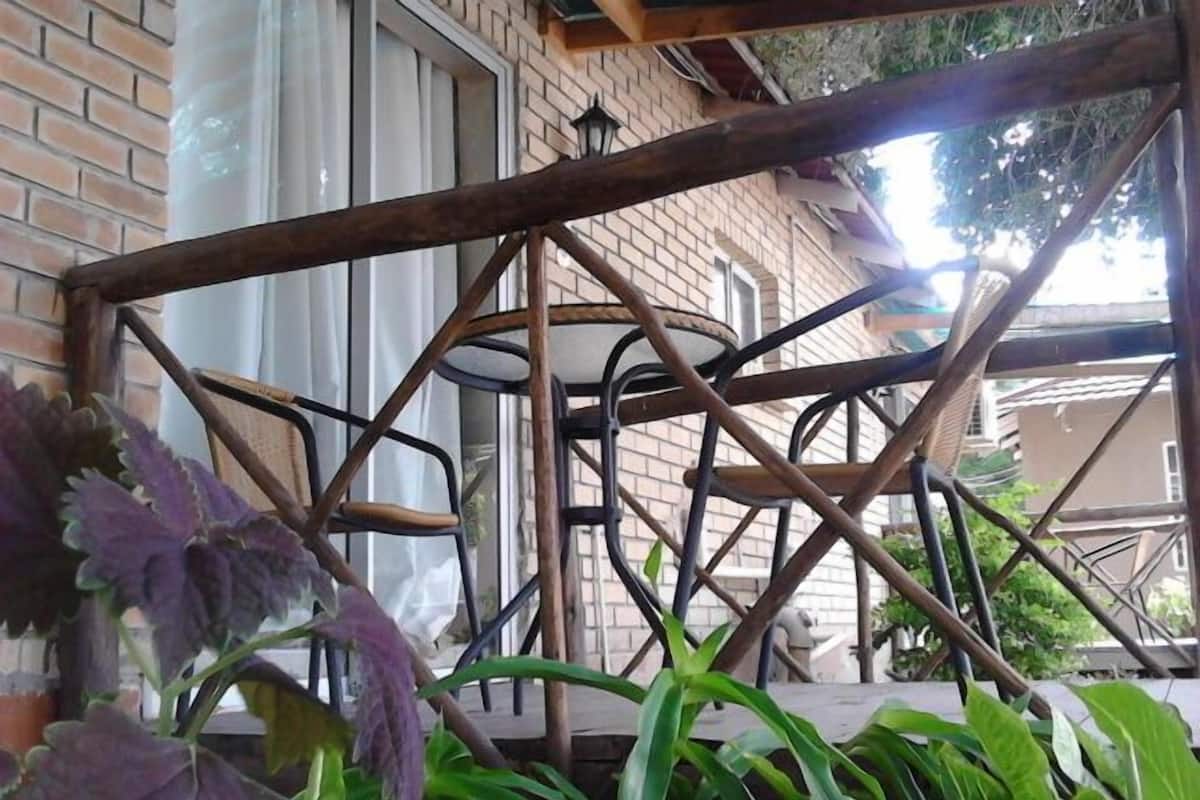 A metal balcony structure with a brick wall in the background.