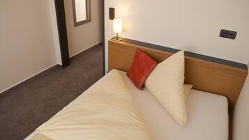 Ein Hotelzimmer mit einem Bett, einem Nachttisch mit Lampe und einer Steckdose.