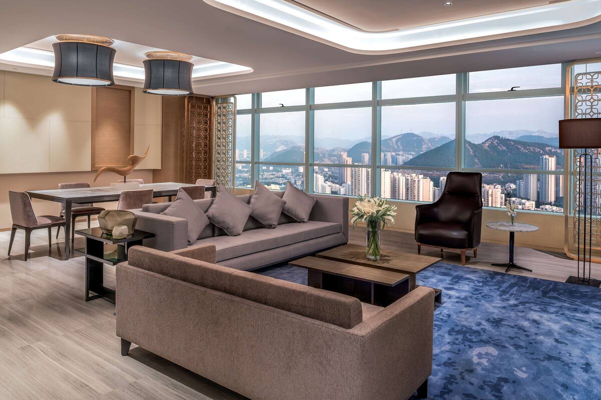 A modern living room with a sofa, coffee table, and dining area.