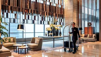 A modern lobby with a large window, a reception desk, and a clean, polished floor.