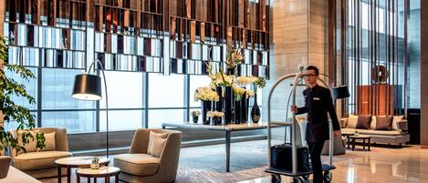 A modern lobby with a large window, a reception desk, and a clean, polished floor.