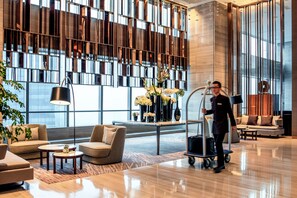 A modern lobby with a large window, a reception desk, and a clean, polished floor. - Hilton Jinan South Hotel & Residences (Jinan)