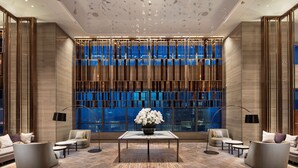 A modern lobby with a central table, seating areas, and a large window with a view. - Hilton Jinan South Hotel & Residences (Jinan)