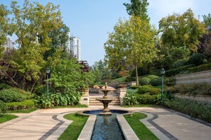 A landscaped garden with a central fountain, surrounded by well-maintained hedges and trees. - Hilton Jinan South Hotel & Residences (Jinan)