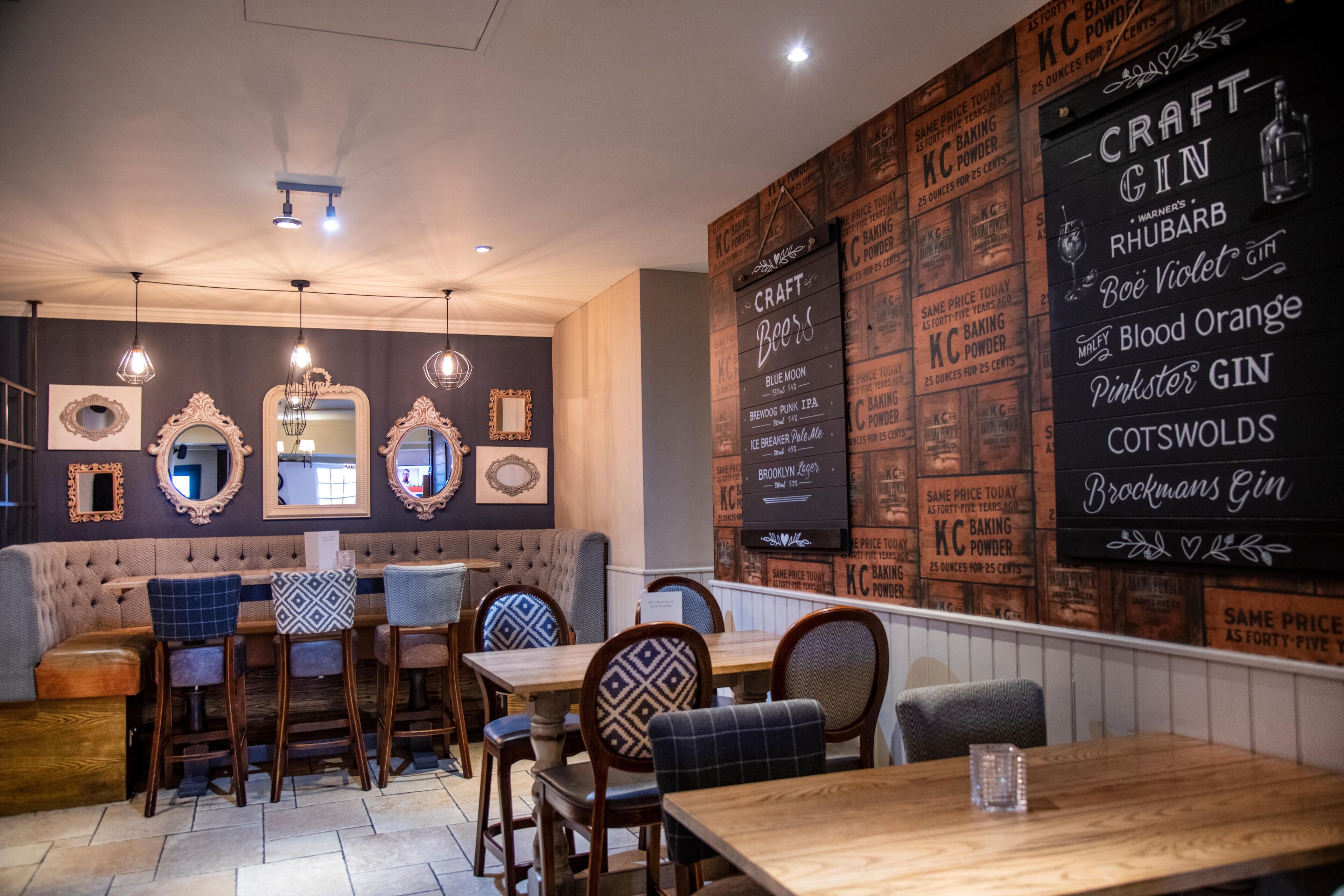 Een restaurant interieur met een bar, houten tafels en stoelen.