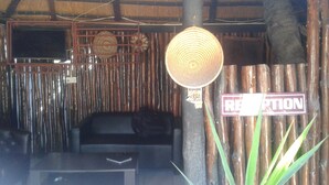 A reception area with a sign, a woven basket, and a television mounted on the wall.