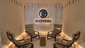 Jäähuone, jossa on neljä tuolia ja pöytä, pyöreä tunnus ja seinässä sana »HATTUSA».