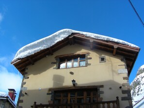 Eine Berglodge mit schneebedecktem Dach und Holzbalken.