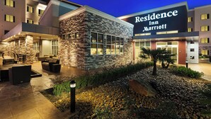 A modern hotel exterior with a stone facade, outdoor seating area, and a clear view of the entrance. - Residence Inn by Marriott Houston West/Beltway 8 at Clay Rd. (Houston)