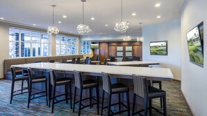 A modern hotel lobby with a large reception desk, multiple bar stools, and a patterned carpet. - Residence Inn by Marriott Houston West/Beltway 8 at Clay Rd. (Houston)