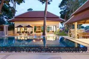 A modern house with a swimming pool, lounge chairs, and a covered patio area. - Nai Harn Baan-Bua Villas (Rawai)