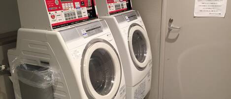 A private laundry room with two front-loading washing machines and a dryer.