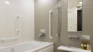 A modern bathroom with a large bathtub, a shower, a sink, and a mirror.