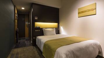 Habitación de hotel con cama, mesita de noche, lámpara y un cuadro en la pared.