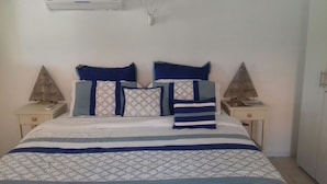 Een slaapkamer met een bed, twee nachtkastjes en een witte muur.