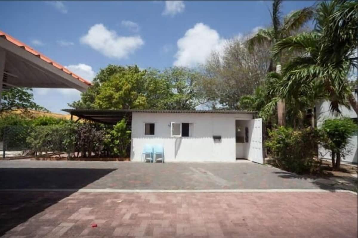 A small, single-story building with a flat roof and a covered patio area.