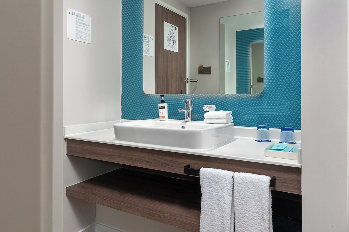 A bathroom with a white sink, a mirror, and a towel rack.