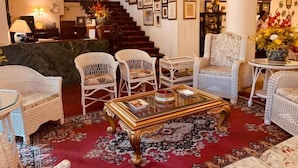 A grand lobby with a staircase, wicker furniture, and a red carpet. - The Elgin Fairlawn Kolkata (Kolkata)