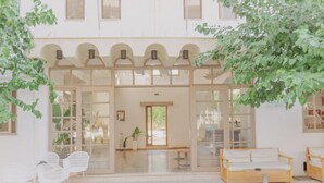 A hotel lobby with a central seating area, a reception desk, and a large glass door entrance. - Apollon (Agios Nikolaos)