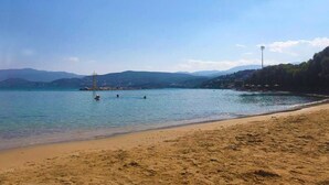 A beach with clear water, a sandy shore, and distant mountains. - Apollon (Agios Nikolaos)