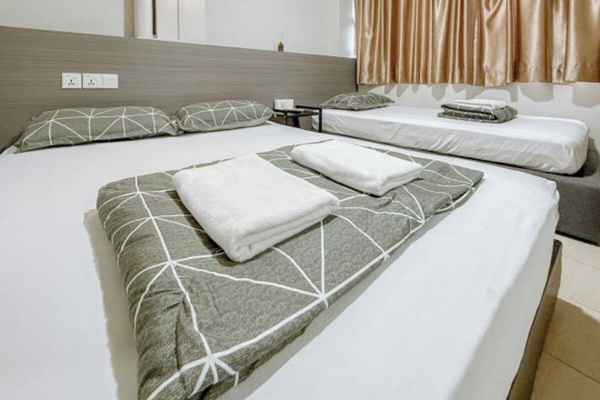A hotel room with a large bed, two bedside tables, and a headboard.