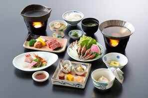 A variety of Japanese dishes arranged on a table, including sushi, sashimi, and other delicacies, with hot pots and bowls of soup. - Midagahara Hotel (Tateyama)