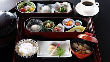 A traditional Japanese meal set on a tray with various dishes including rice, soup, and vegetables.