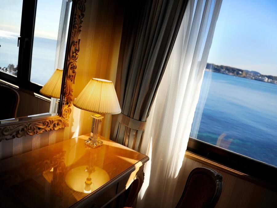 Une chambre avec vue sur la mer, une lampe et un miroir.