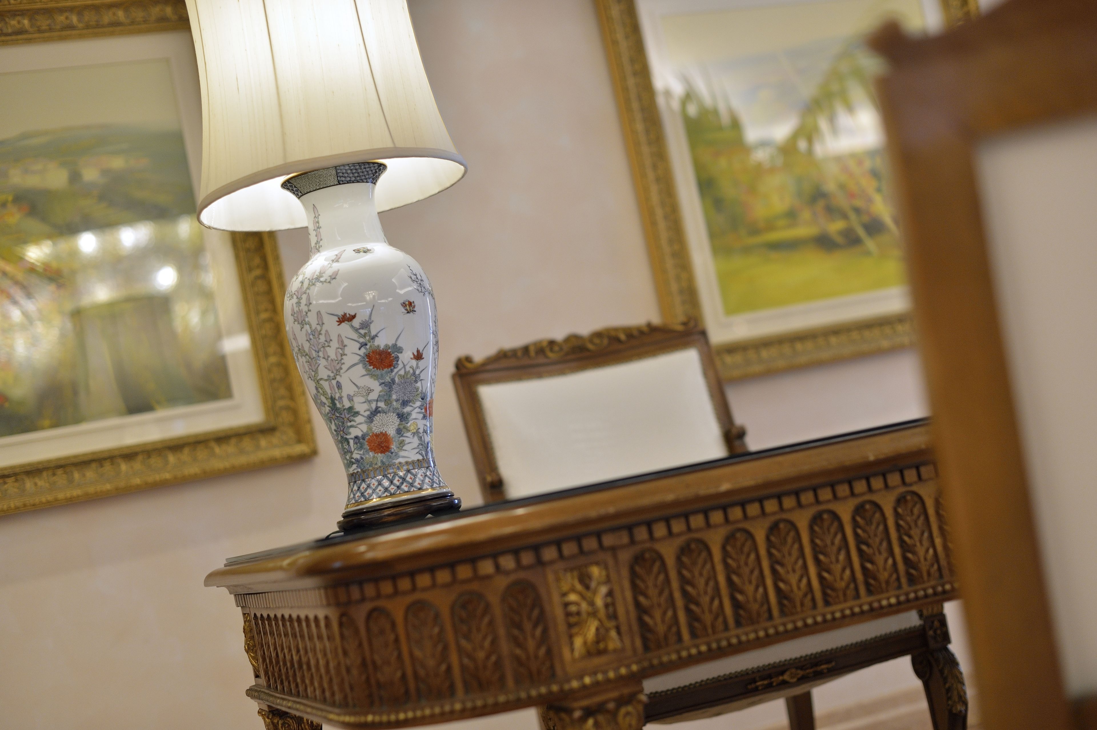 Una mesa con una lámpara decorativa y un cuadro en el fondo.