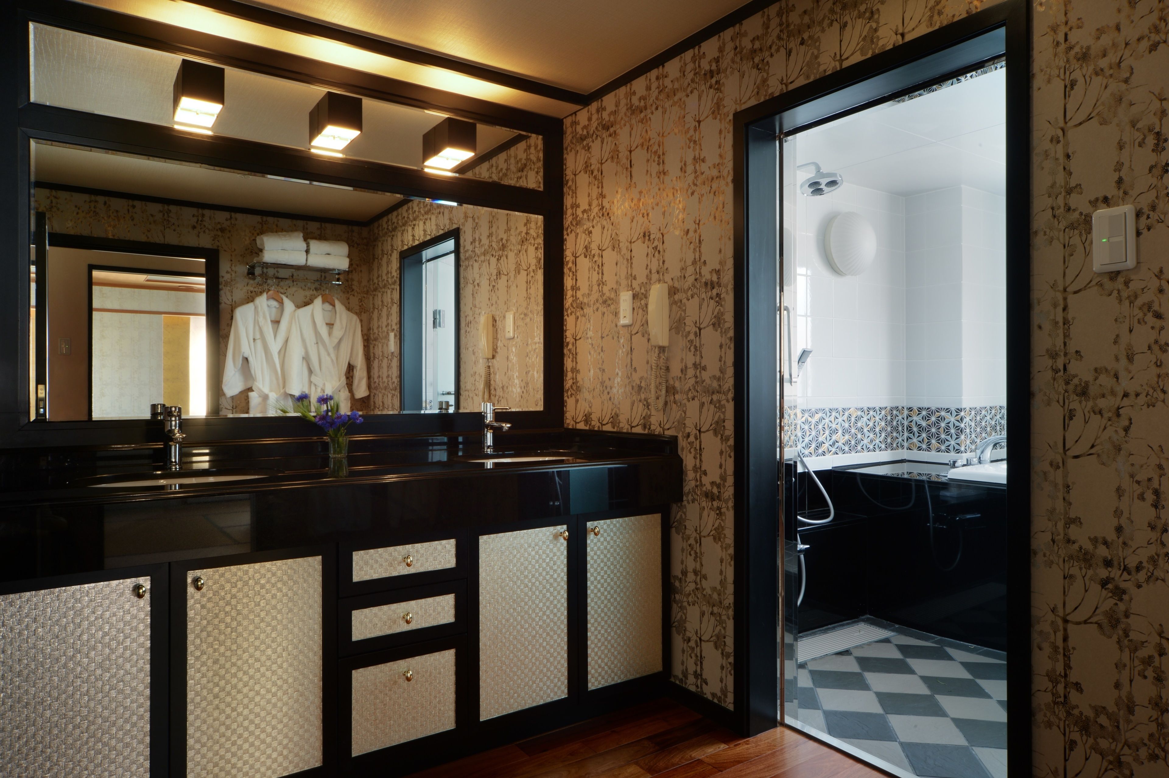 Un bagno moderno con uno specchio grande, due lavandini e una doccia.