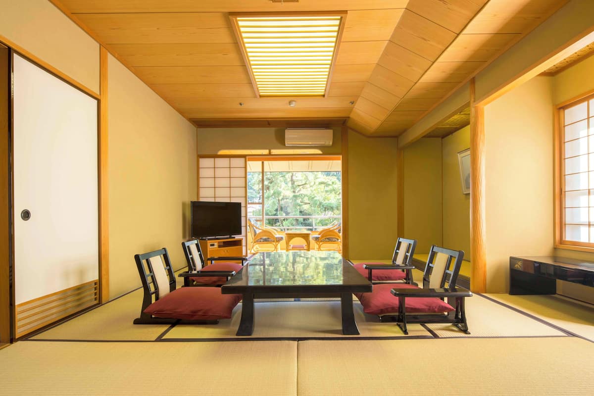 A traditional Japanese room with tatami flooring, a low table, and wooden sliding doors.