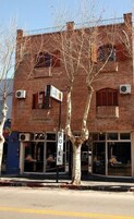 Un edificio de ladrillo con un letrero que dice "HOTEL" y un árbol en primer plano.