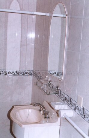 A bathroom with a sink, mirror, and towel rack. - Hotel Spa Brisolei (San Bernardo del Tuyú)