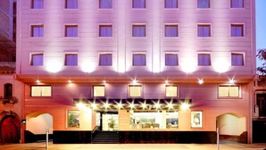A multi-story hotel with a symmetrical facade, evenly spaced windows, and a central entrance with a staircase.