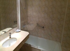 Un baño con lavamanos, espejo y ducha.