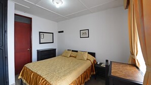 Une chambre à coucher avec un lit, une table de chevet et une armoire.