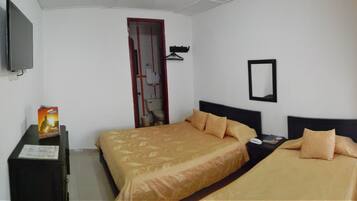 Quarto de hotel com duas camas, uma televisão, um guarda-roupa e um espelho.