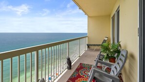 Ein Balkon mit Meerblick, einem Blumentopf und einem Stuhl.