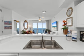 Una cucina moderna con un'isola grande, lavello doppio e vista all'esterno.