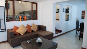 A modern living room with a brown sofa, a coffee table, and a large mirror. - Apartamento Viscaya (Medellin)