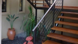 A staircase with wooden steps and a metal railing, leading to an upper floor. - Costa Iguazú Apart Hotel (Puerto Iguazú)