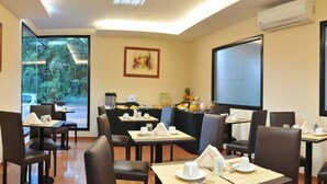 A dining area with tables set for breakfast, including fruits and beverages. - Costa Iguazú Apart Hotel (Puerto Iguazú)