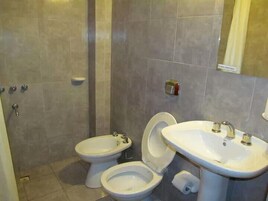 Un baño con dos inodoros, un lavabo y un espejo.