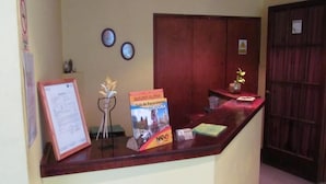 A reception desk with a framed document, a flower vase, and a travel guidebook.