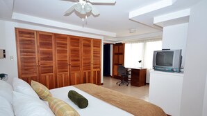 Ein Hotelzimmer mit Bett, Schreibtisch mit Stuhl, Fernseher und Holzschränken.