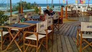 Un espace extérieur aménagé avec des tables et des chaises en bois, chacune portant l’inscription « antel ».