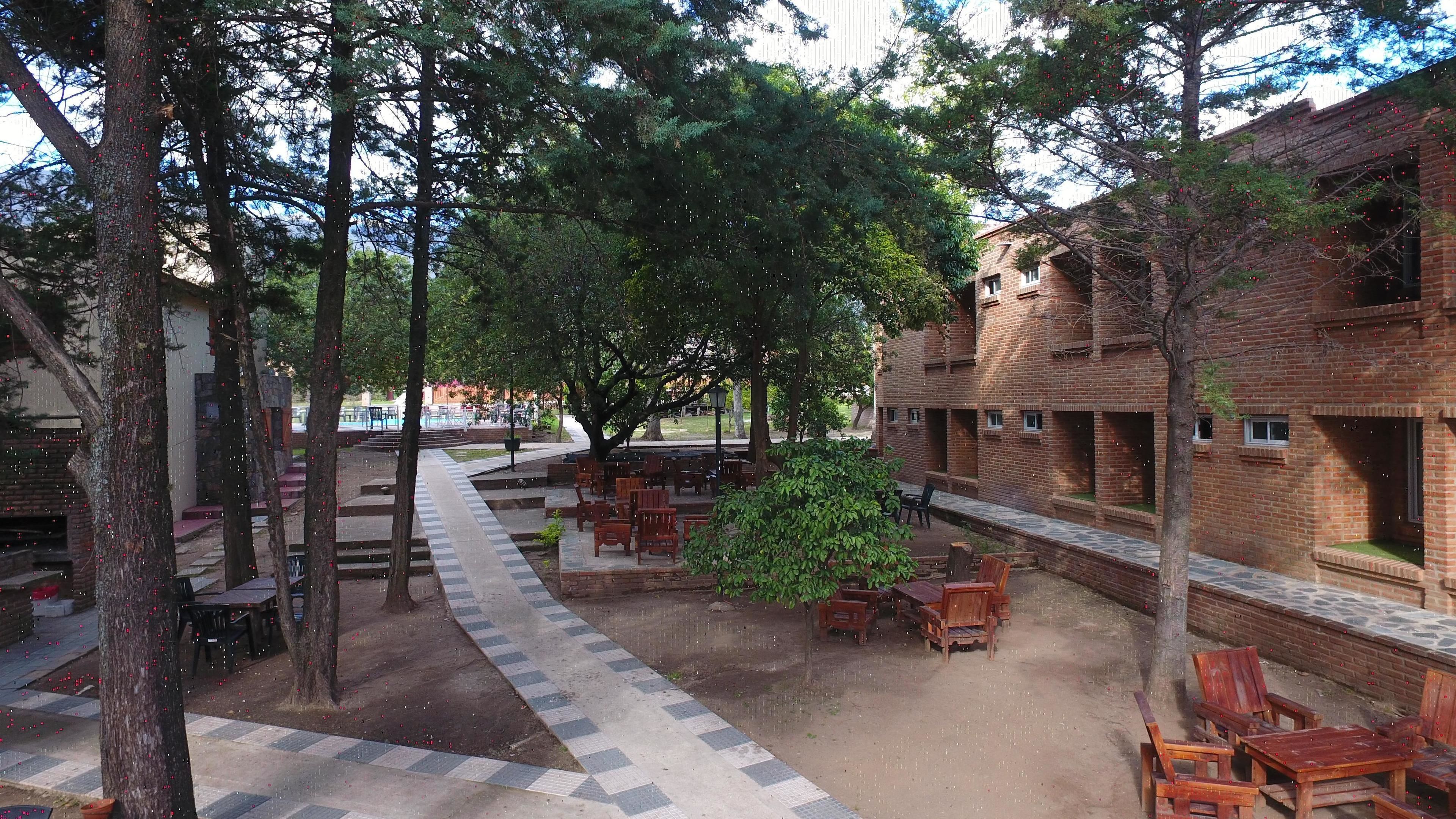 An outdoor patio area with wooden furniture and brick buildings.